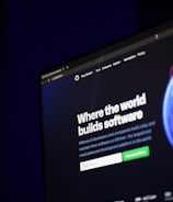 A computer screen displays a website with the text 'Where the world builds software' prominently featured. Below the text, there are fields for users to input their email address, along with additional descriptions about the platform and its capabilities. The website has a dark background with bright text, indicating a professional tech-based service.